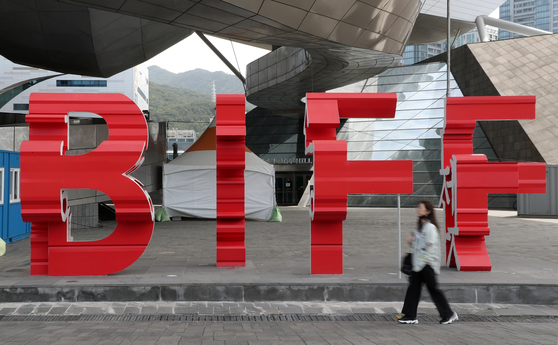 A passerby walks across the Busan International Film Festival (BIFF) logo in front of the Busan Cinema Center in Haeundae District, eastern Busan, on May 24. [NEWS1]