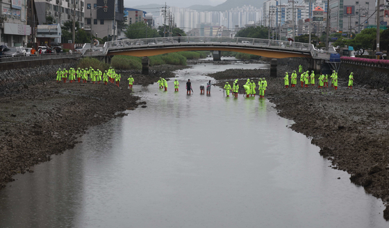 Police on Tuesday search for the body of an infant suspected to have been dumped in a stream in Geoje, South Gyeongsang in September last year. [YONHAP] 