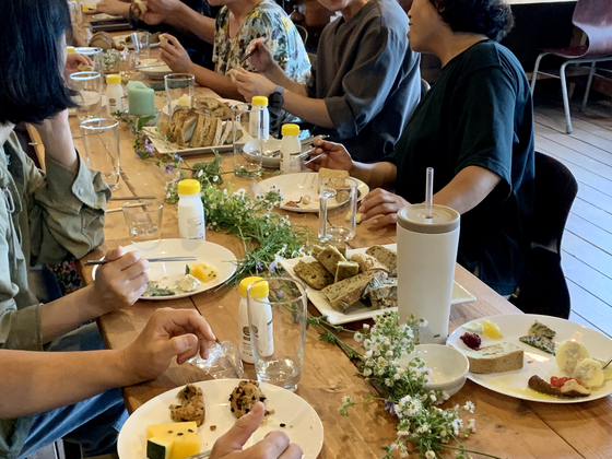 Some 35 local farmers, cooks and merchants eat foods made mostly with locally grown wheat inside a cabin at a wheat farm in Gongju, South Chungcheong, on June 29. [LEE JIAN]