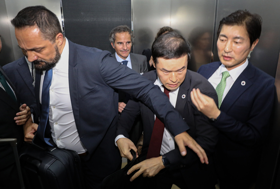 IAEA Director General Rafael Mariano Grossi being escorted to another relocation in avoiding protestors at the Gimpo International Airport on Friday. [YONHAP] 