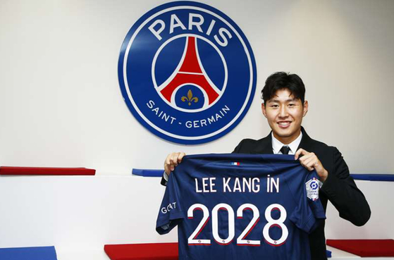 Lee Kang-in poses with a Paris Saint-Germain shirt in a photo released by the club on Saturday.  [PARIS SAINT-GERMAIN]