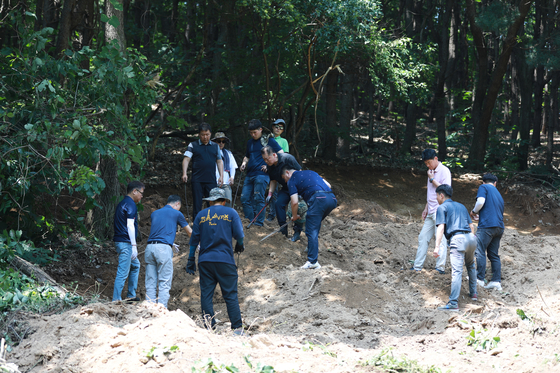 Police last Thursday search for a baby's body suspected of having been buried on a hillside in Yongin, Gyeonggi, in 2015. The police on Monday said they concluded the search as they were unable to find the body. [GYEONGGI NAMBU PROVINCIAL POLICE] 