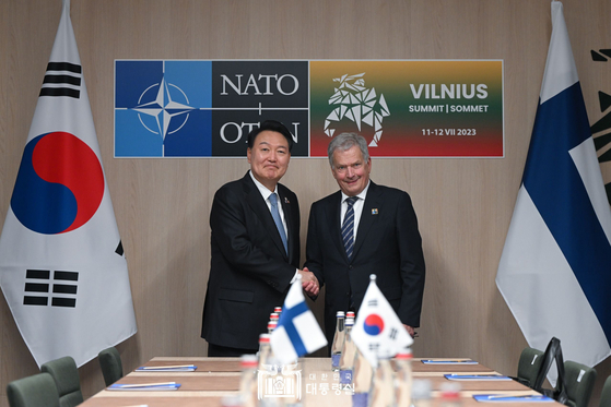 President Yoon Suk Yeol, left, shakes hands with Finnish President Sauli Niinisto during their talks in Vilnius, Lithuania, on Wednesday. [JOINT PRESS CORPS]