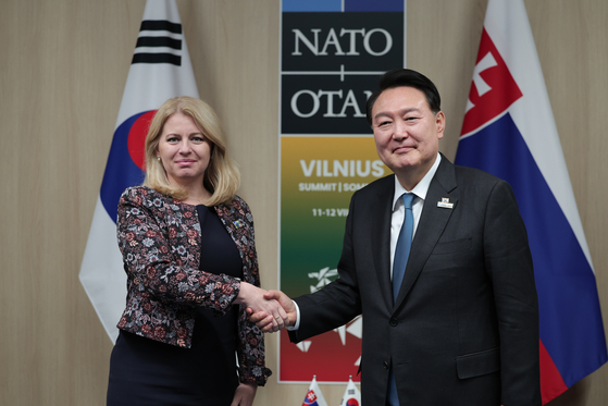 President Yoon Suk Yeol, right, shakes hands with Slovak President Zuzana Caputova during their talks in Vilnius, Lithuania, on Wednesday. [JOINT PRESS CORPS]