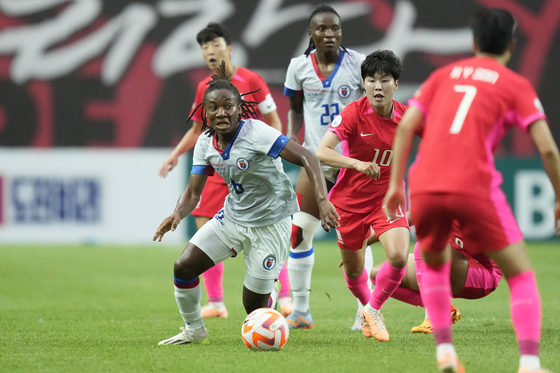 Haiti's Melchie Dumornay, left, fights for the ball with Korea's Ji So-yun during a friendly at Seoul World Cup Stadium in central Seoul on July 8.  [AP/YONHAP]