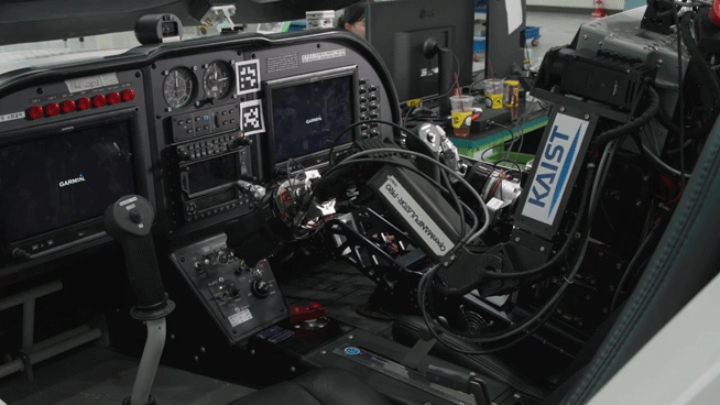 Pibot, a humanoid pilot robot developed by a KAIST research team, sits in a cockpit of a flight simulator. [KAIST]