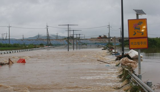 Water from the Miho River in Osong-eup, Cheongju in North Chuncheong flows into a nearby underpass as heavy rain pounded the area last Saturday. At least 14 people were killed as of Monday after being trapped in the flooded underpass. [YONHAP]