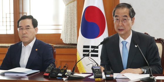 Prime Minister Han Duck-soo, right, speaks during a meeting of the National High-Tech Strategic Industry Committee at the government complex in central Seoul on Thursday. Sitting on his left is Lee Chang-yang, Minister of Trade, Industry and Energy. [NEWS1] 