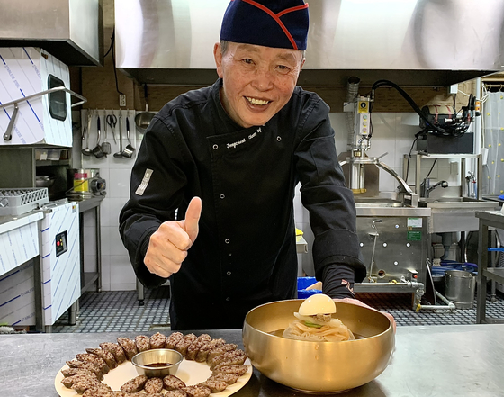 Yoon Jong-cheol, the owner-chef of Dongmu Bapsang in Goyang-si, Gyeonggi, poses with sundae (Korean blood sausage) and nanaengmyeon (Korean cold noodles). [LEE JIAN]