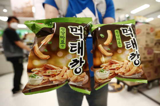 A customer holds up two bags of Muktaekkang after purchasing them at a discount store in Seoul on Sunday. [NEWS1]