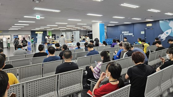 Workers at Coupang's distribution center in Hwaseong, Gyeonggi, take a rest on the first floor during their lunch break. [JANG SEO-YUN]