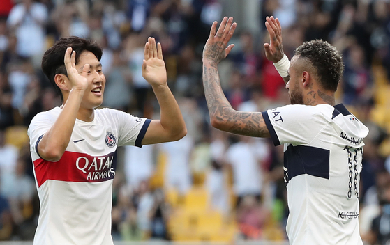 Lee Kang-in, left, congratulates Neymar after the Brazilian forward scored Paris Saint-Germain's second goal in a game against Jeonbuk Hyundai Motors at Busan Asiad Main Stadium in Busan on Thursday. [NEWS1]