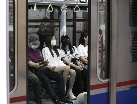 Passengers wearing masks board a subway train at Suyu Station in northern Seoul on Wednesday. [NEWS1]