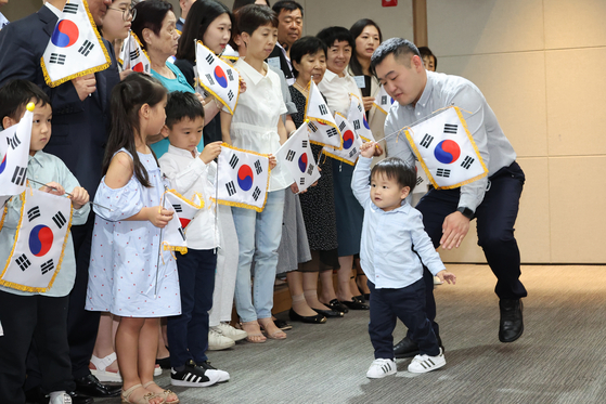 Foreign-born descendants of Korean freedom fighters against Japanese colonial rule wave the Korean flag after they were given Korean citizenship on Monday. The Justice Ministry held a ceremony to award Korean citizenship to 20 descendants of freedom fighters, including nine Russians, two Chinese and two Americans, to celebrate the 78th anniversary of Korea’s independence from colonial rule. The Korean government has been tracking down descendants of Korean freedom fighters since 2004 using DNA. Some 1,345 descendants of freedom fighters have been given Korean citizenship. [YONHAP] 