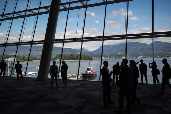Delegates are silhouetted in a venue of a conference in Vancouver, British Columbia on July 11. [AP/YONHAP]