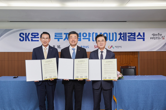 SK On CEO Jee Dong-seob, center, takes a photo with South Chungcheong Governor Kim Tae-heum, right, and Seosan Mayor Lee Wan-seob after signing an agreement of $1.1 billion battery investment in the city Wednesday. [SK ON] 