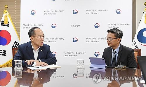 Finance Minister Choo Kyung-ho, left, speaks with an official from the global rating appraiser S&P Global Ratings Seoul on Aug. 28. [YONHAP]