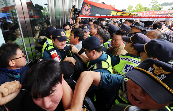 Member of veterans associations who are against the construction of a park commemorating Jeong Yul-seong try to break in to the city government of Gwangju on Wednesday. [YONHAP]