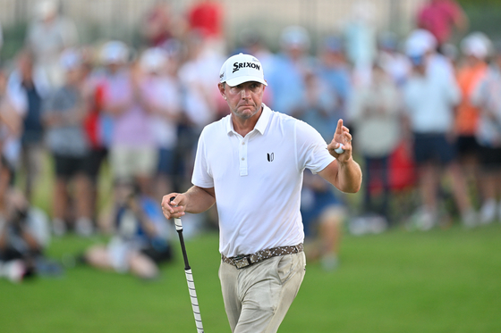 Lucas Glover waves after making a putt on the 18th green during the first playoff hole during the final round of the FedEx St. Jude Championship at TPC Southwind in Memphis, Tennessee on Aug. 13. [GETTY IMAGES]