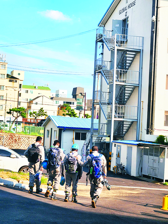 Foreign workers pass by Flower Rock Sea Sound Road in Ulsan. [KIM YOUN-HO]