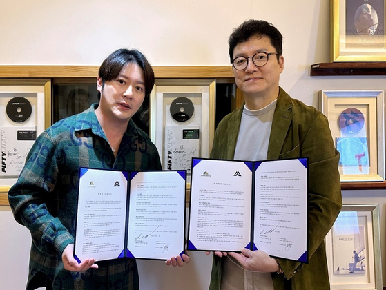 Oscar Jun, CEO of K-pop agency Attrakt at right, and David Yong, CEO of Singaporean investment company Evergreen Group Holdings, pose for photos after signing an MOU on Aug. 25. [ATTRAKT]