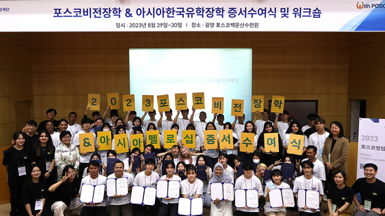 A total of 17 Posco Asia Fellowship recipients and 47 Posco Vision Scholarship winners pose for a photo during a joint scholarship award ceremony on Tuesday. [POSCO TJ PARK FOUNDATION]