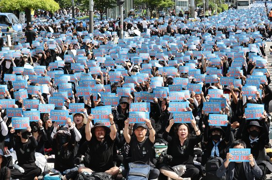 Teachers rally in front of the National Assembly building in Yeouido, western Seoul, on Saturday to commemorate the death of an elementary teacher who took her own life in July and demand legislative measures to protect them from malicious complaints from students and parents. [NEWS1] 
