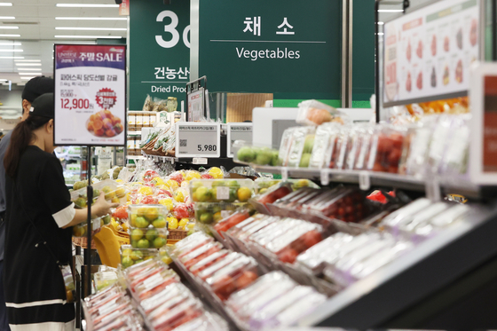 People at the vegetable section of a supermarket in Seoul on Sunday. As Koreans prepare for this year’s Chuseok harvest festival later this month, fruits became more expensive while vegetables became cheaper compared to the year before. According to the Korea Agro-Fisheries & Food Trade Corporation, the wholesale prices of apples and pears increased 60.9 percent and 26.9 percent, while prices for cabbages and white radishes each fell 51 and 29.7 percent. [YONHAP]
