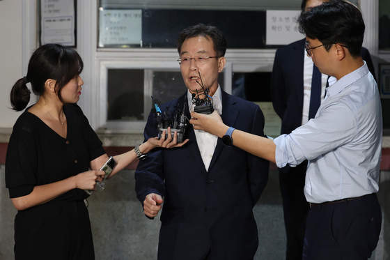 Kim Man-bae answers questions in front of the Seoul Detention Center in Uiwang, Gyeonggi, where he was released on Thursday. [YONHAP]