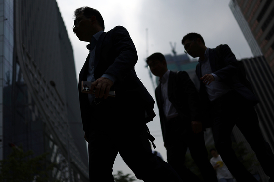 Pedestrians walk along the streets of Yeouido in western Seoul in June. [YONHAP]