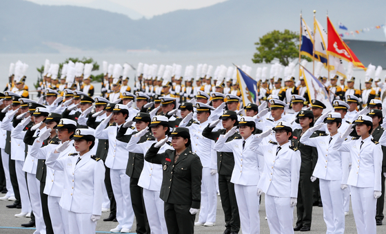 Newly commissioned Navy and Marine officers raise their hands in salute during a commissioning ceremony held at the Republic of Korea Naval Academy in Changwon, South Gyeongsang, on May 26. [NEWS1]
