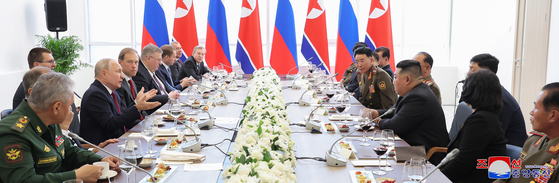Russian President Vladimir Putin, center left, speaks to North Korean leader Kim Jong-un, center right, during a state reception dinner held after Wednesday's summit at Vostochny Cosmodrome in Amur Oblast, Russia. [KOREAN CENTRAL NEWS AGENCY]