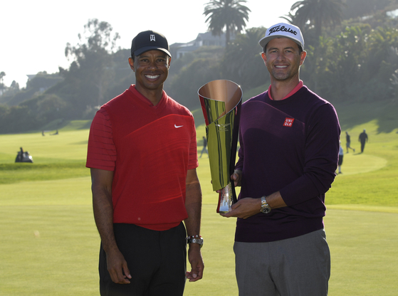 Adam Scott, right, poses with tournament host Tiger Woods and the trophy after winning the the Genesis Invitational at Riviera Country Club on Feb. 16, 2020 in Pacific Palisades, California. [GETTY IMAGES]