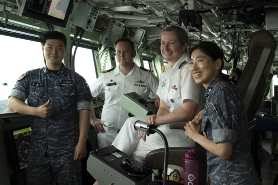 Commander Coates of HMCS Vancouver, second from right, and Lieutenant Commander Thwaites, executive officer of the vessel, third from right, pose for a picture with ROK Navy liaison officers during the re-enactment of the Incheon Landing Operations on Friday in Incheon. [ALISA STRELLEY/CANADIAN ARMED FORCES PHOTO]