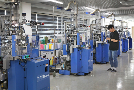 An employee at the Seoul Socks Manufacturing Support Center in Dobong District, northern Seoul, sets a socks-knitting machine on Thursday. [PARK SANG-MOON]