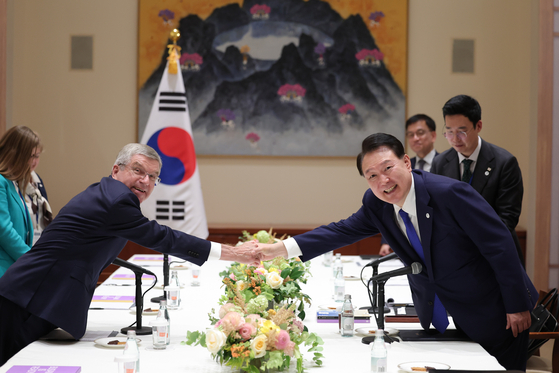 Korean President Yoon Suk Yeol, right, shakes hands with International Olympic Committee President Thomas Bach in New York on Tuesday, on the sidelines of the UN General Assembly. [JOINT PRESS CORPS]