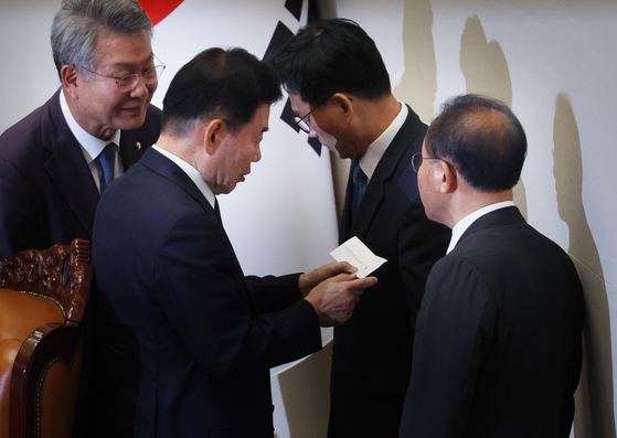 National Assembly Speaker Kim Jin-pyo examines one of the ballots cast during the vote on the arrest motion against Democratic Party leader Lee Jae-myung on Thursday afternoon. [YONHAP]