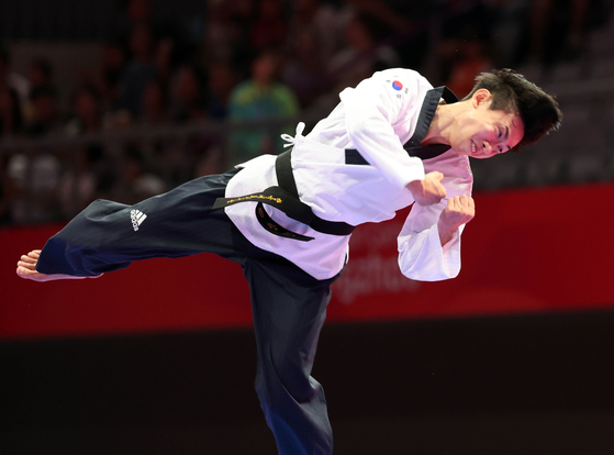 Taekwondo practitioner Kang Wan-jin celebrates after winning a gold medal in the men's individual poomsae at the Hangzhou Asian Games at Lin'an Sports Culture & Exhibition Centre in Hangzhou, China on Sunday. [YONHAP]