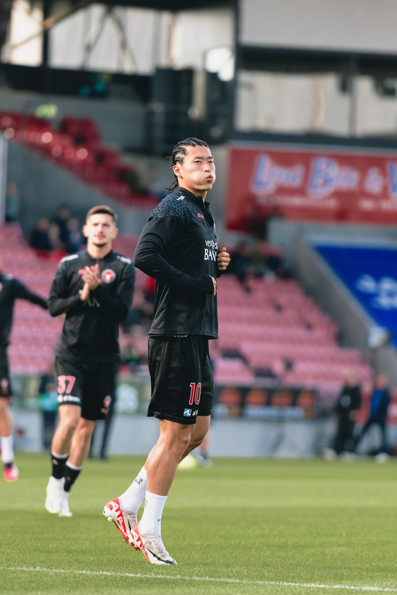 FC Midtjylland's Cho Gue-sung warms up at the MCH Arena in Herning, Denmark ahead of a Danish Superliga match against Odense Boldklub in a photo shared on FC Midtjylland's official Facebook page on Sunday. Cho, who appeared sporting an unexpected new hairstyle, scored a goal during the game, leading his side to a 2-1 victory and managing his fifth goal for the club this season. [SCREEN CAPTURE]