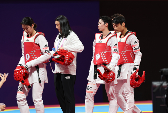 The Korean taekwondo team reacts after losing the final of the mixed gender team to China at Lin'an Sports Culture Convention & Exhibition Center Gymnasium in Hangzhou, China on Monday. [YONHAP] 
