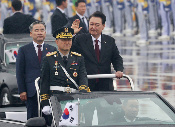 President Yook Suk Yeol, right, conducts a military review in a car during a ceremony to mark the 75th anniversary of Armed Forces Day at Seoul Air Base in Seongnam, Gyeonggi, Tuesday. [JOINT PRESS CORPS]
