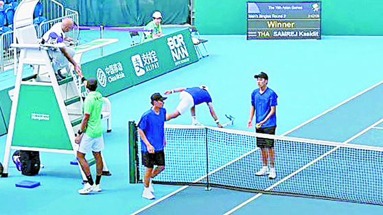 Korean tennis player Kwon Soon-woo smashes his racket on the floor after losing to Samrej Kasidit of Thailand in the second round of the men's singles tournament at the Asian Games on Monday. [JOONGANG ILBO]