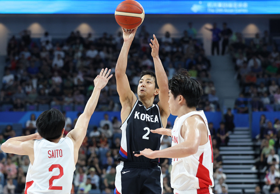 Korea's Heo Hoon, center, shoots during a Hangzhou Asian Games group stage game against Japan at Hangzhou Olympic Sports Centre Gymnasium in Hangzhou, China on Saturday. [YONHAP]