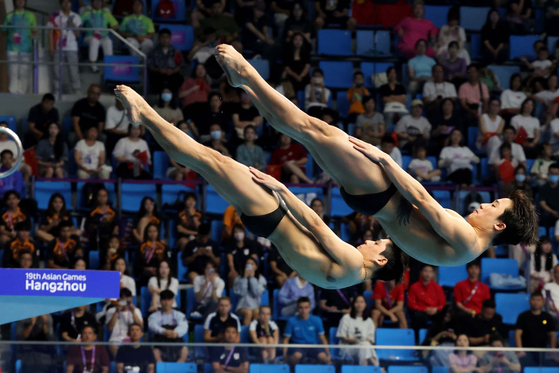 Korean divers Woo Ha-ram and Yi Jae-gyeong compete in the men’s synchronized 3-meter springboard final held at Hangzhou Olympic Sports Centre Aquatic Sports Arena in Hangzhou, China on Saturday. [JOONGANG ILBO] 
