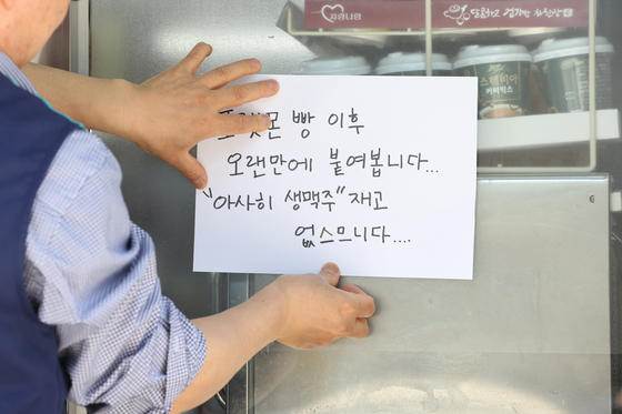 Japanese beer Asahi Super Dry Draft Beer faces scarcity as an 'Out of Stock' notice is posted outside a convenience store in Seoul in May. [YONHAP]