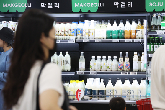 Exports of makgeolli (Korean rice wine) jumped 22.6 percent last year compared to 2020, according to recent data compiled on the Korea Agricultural Trade Information website. Customers pass by the makgeolli section at a supermarket in Seoul on Tuesday. [YONHAP]