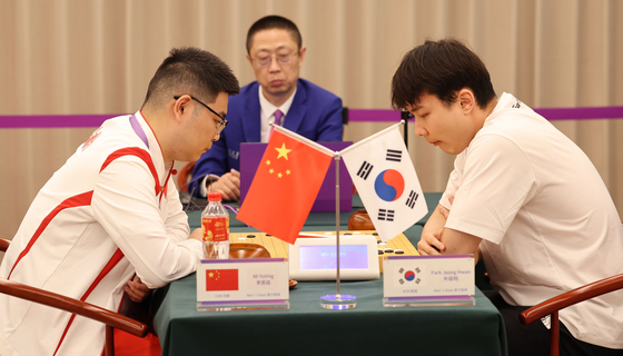 Korean Go pro Park Jeong-hwan, right, competes against Mi Yuting of China in the men's team final at the Hangzhou Asian Games held at Hangzhou Qi-Yuan Chess Hall in Hangzhou, China on Tuesday. [YONHAP] 