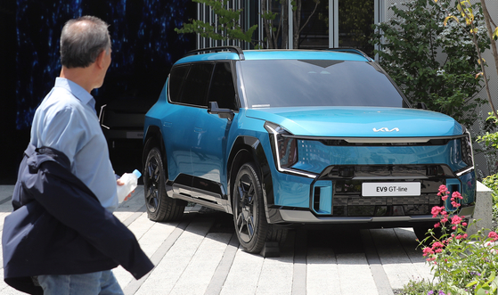 A passerby looks at an EV9 displayed at the Kia EV Unplugged Ground exhibition center in Seongsu-dong, eastern Seoul. [NEWS1] 