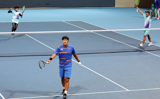 Japan celebrates as Korea's Kim Hyun-soo, wearing blue, alongside Mun Hye-gyeong lose the mixed doubles soft tennis semifinal at the Hangzhou Asian Games on Thursday. [YONHAP]