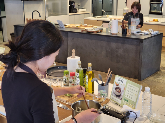 The reporter is seen preparing onion soup, a vegetarian dish, in a cooking class hosted by Sempio Foods Company on Thursday. Utilizing Sempio's Yondu sauce, the soup was easily made and delivered deeper flavors, even for a novice cook like the reporter. [SEO JI-EUN]